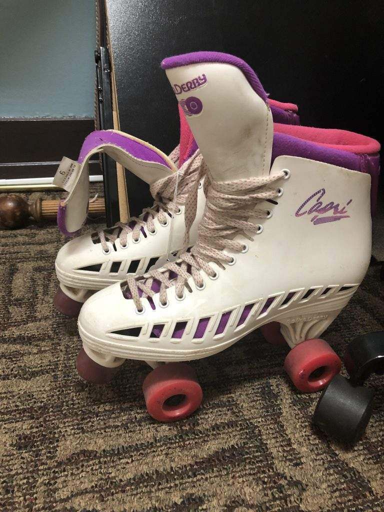 A pair of roller skates are sitting on a carpet.