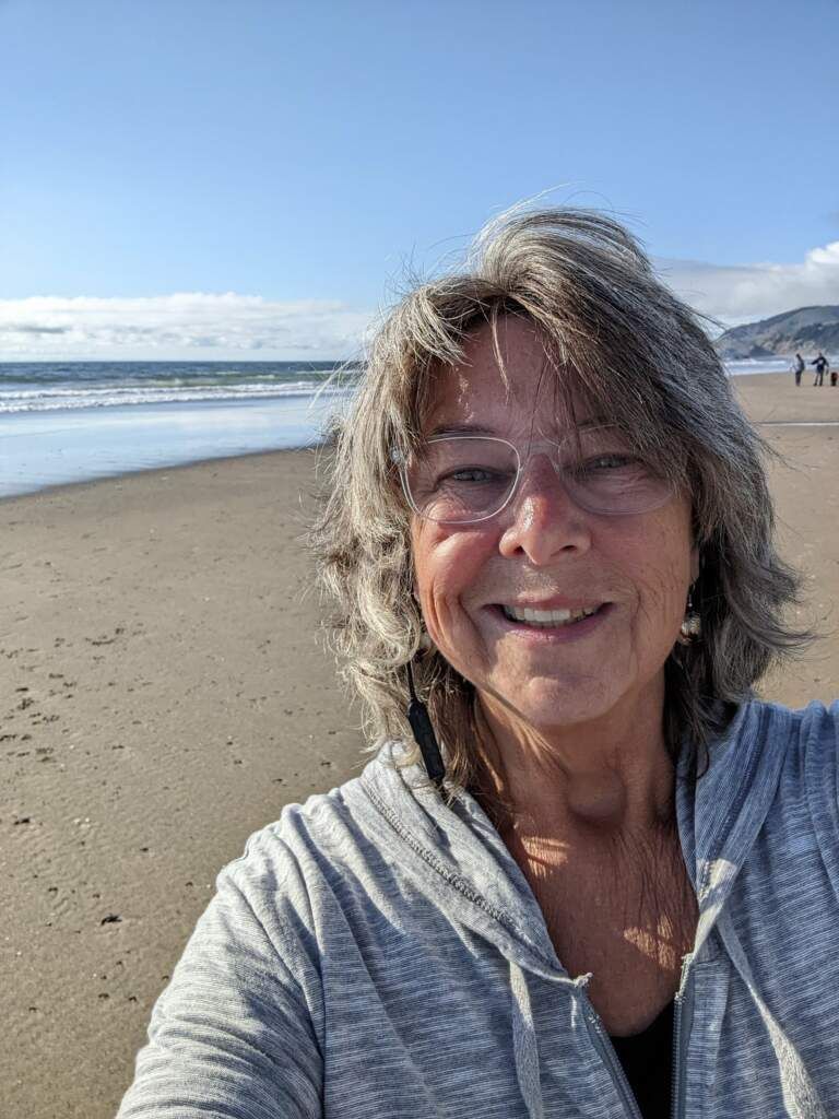 Ruth Hugeback A woman is taking a selfie on the beach.