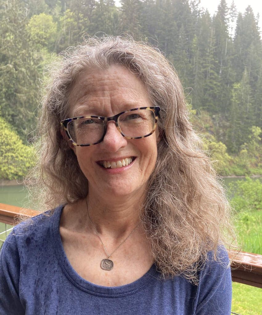 Susan Bard A woman wearing glasses and a blue shirt is smiling for the camera.