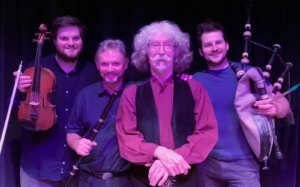 A group of men are standing next to each other on a stage holding musical instruments.