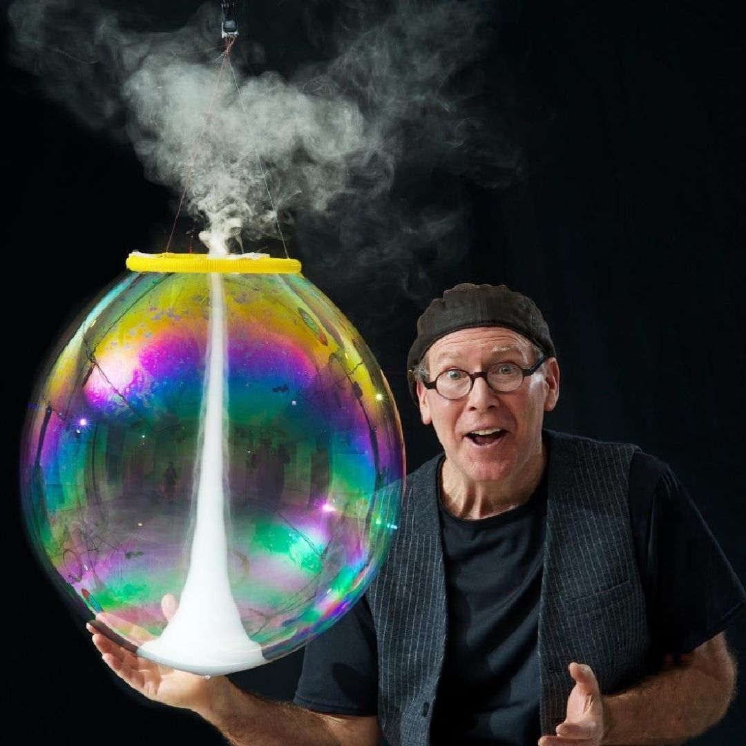 A man is holding a bubble with smoke coming out of it