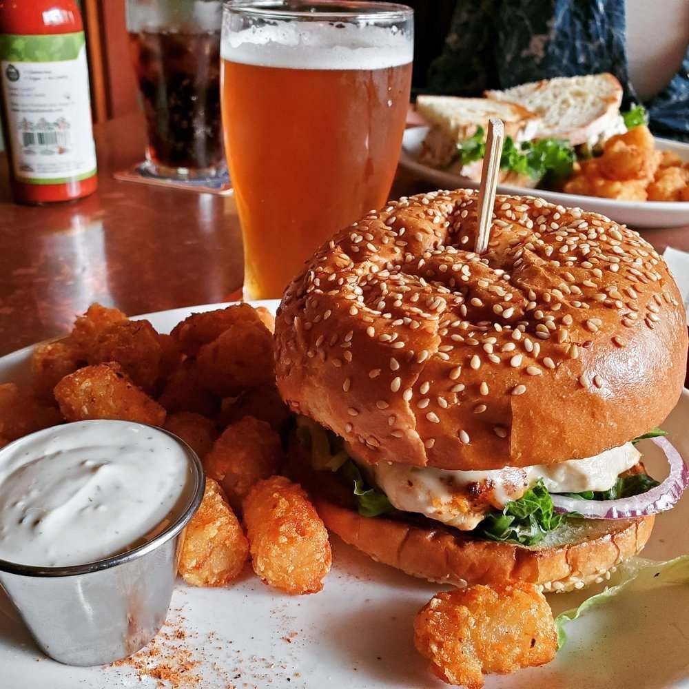 A plate of food with a sandwich and a glass of beer