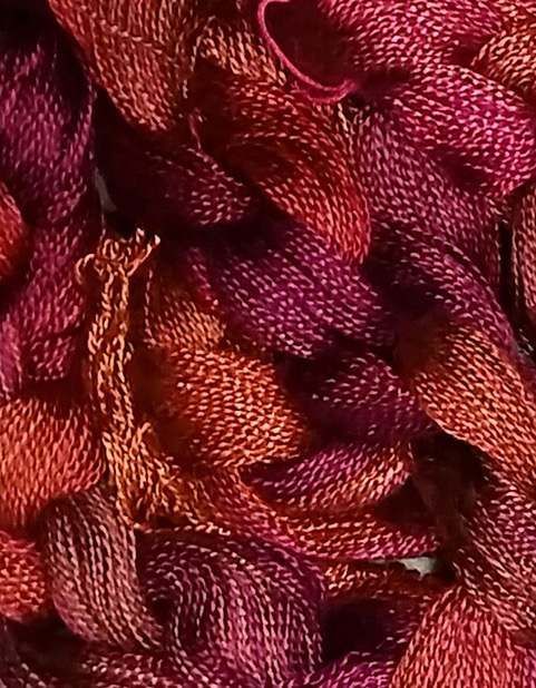A close up of a pile of red and purple yarn