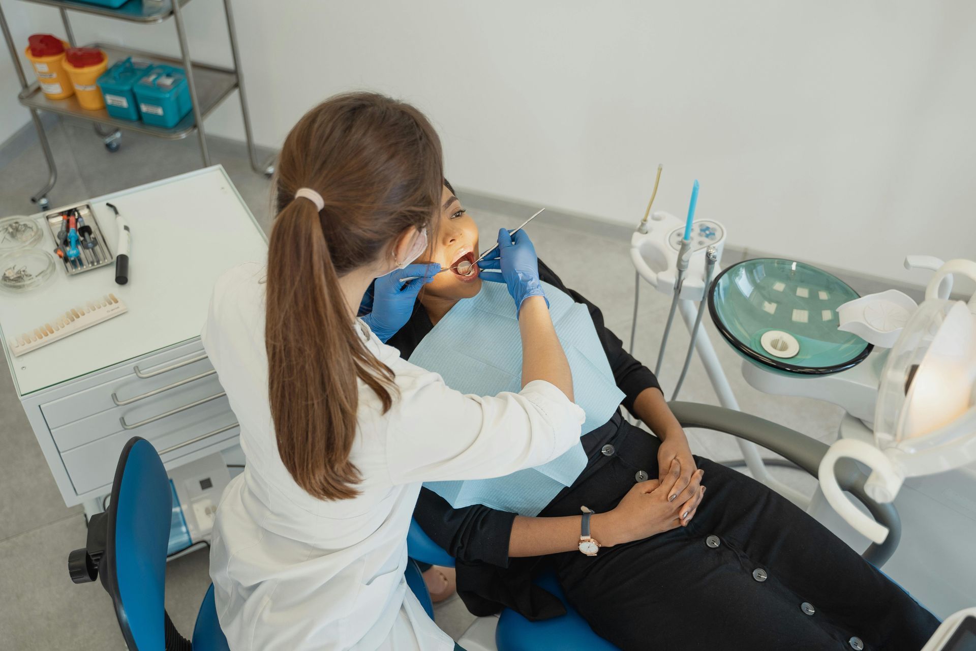 A woman is getting her teeth examined by a dentist in a dental office.