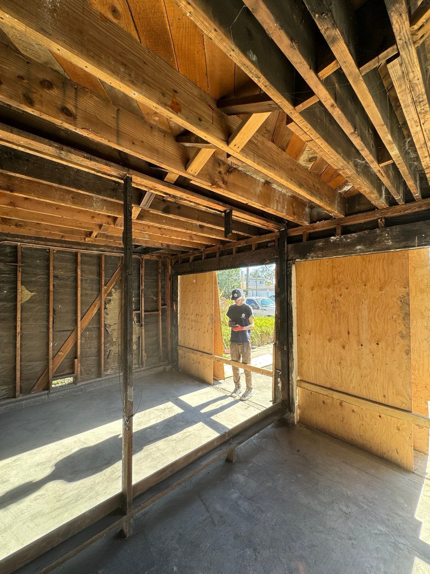 A man is standing in an empty room in a house under construction.