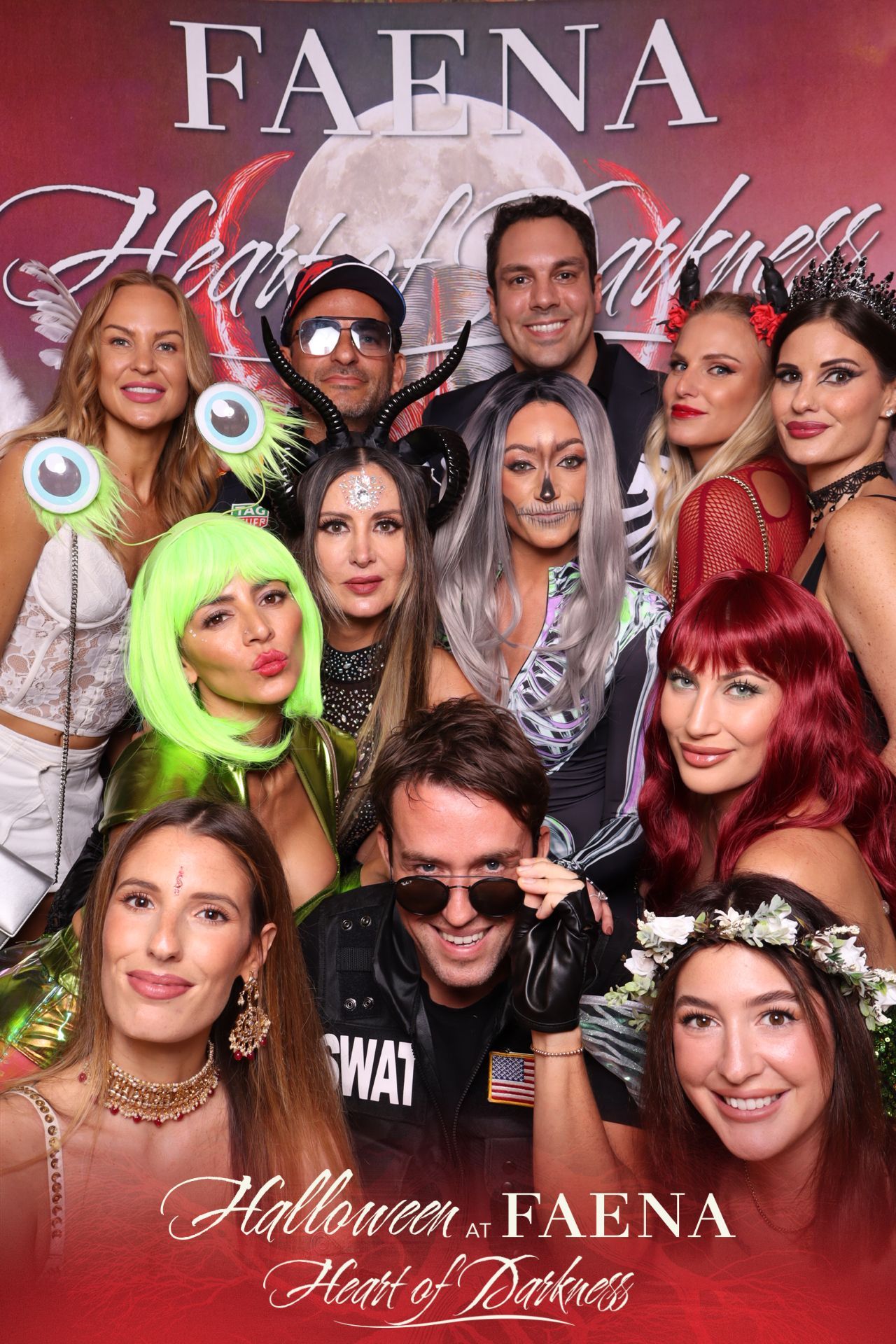 Group of people in colorful Halloween costumes posing at a Faena Halloween event backdrop