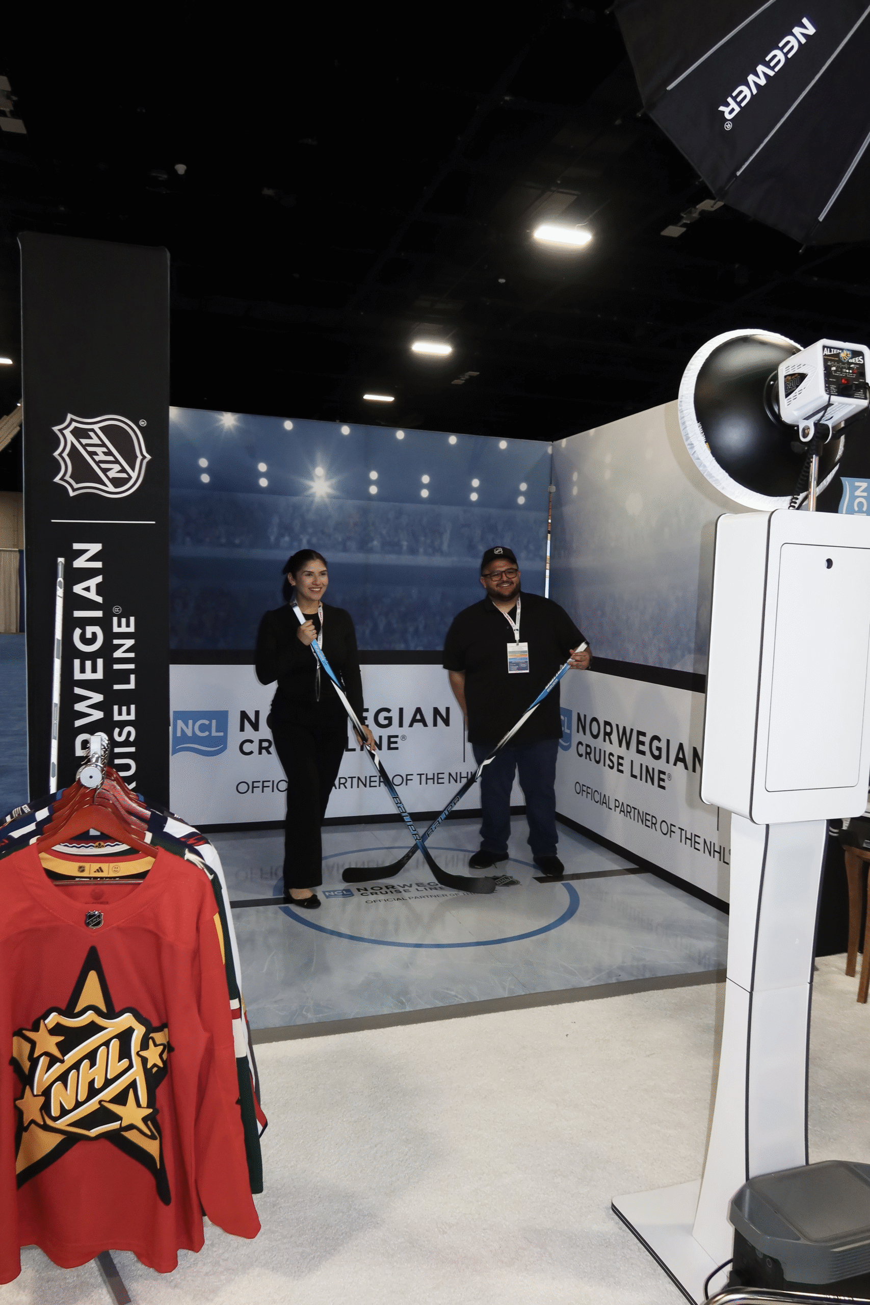 Guests pose inside Norwegian Cruise Line’s custom hockey-rink brand activation at Cruise360 in Fort Lauderdale.