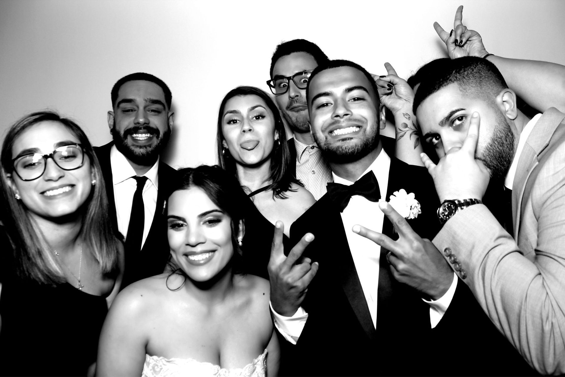 Wedding guests smile and pose together in a black-and-white photo booth portrait from Capturebooth MIA.