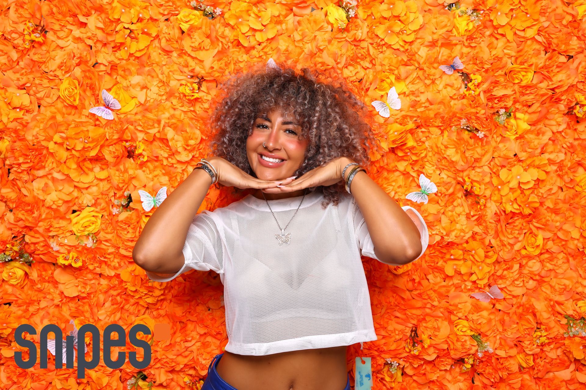 girl in miami photo booth with orange backdrop