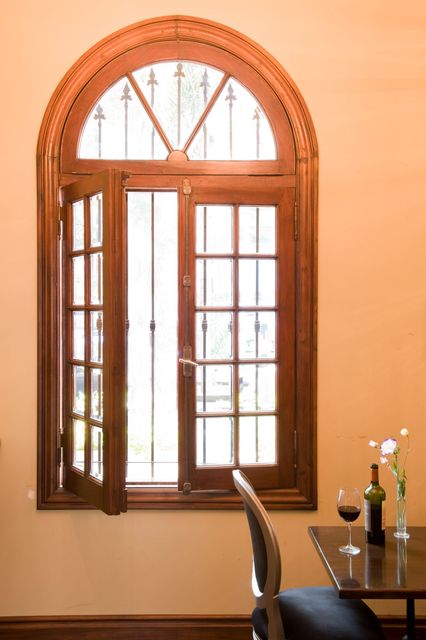 Luminoso soggiorno con porte scorrevoli che si aprono su un balcone con vista sugli alberi verdi; arredamento moderno.
