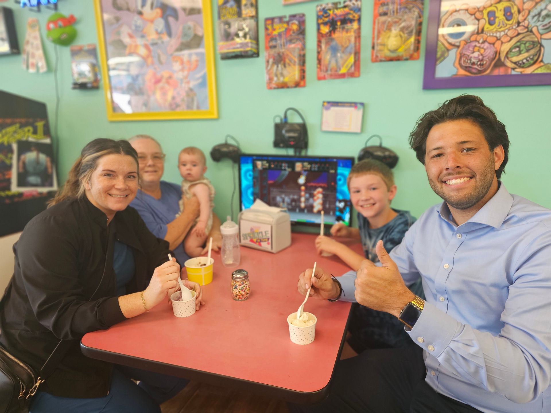 A group of people are sitting at a table eating ice cream.
