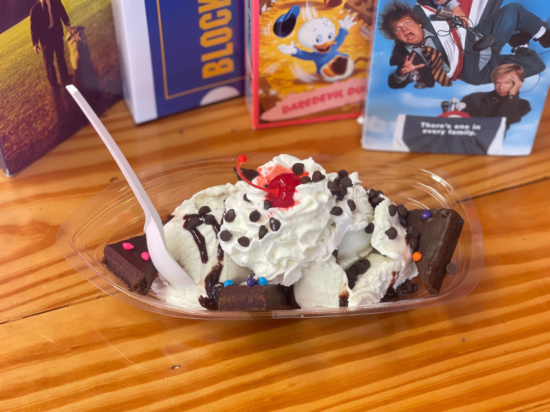 A bowl of ice cream with a spoon on a wooden table