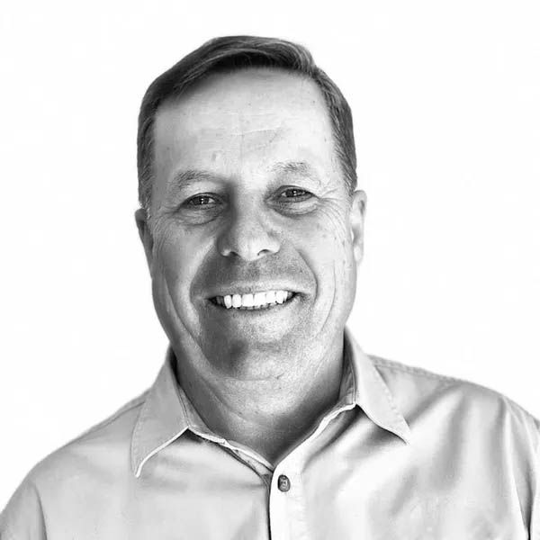 Black-and-white headshot of a smiling Ken Bullen in a collared shirt