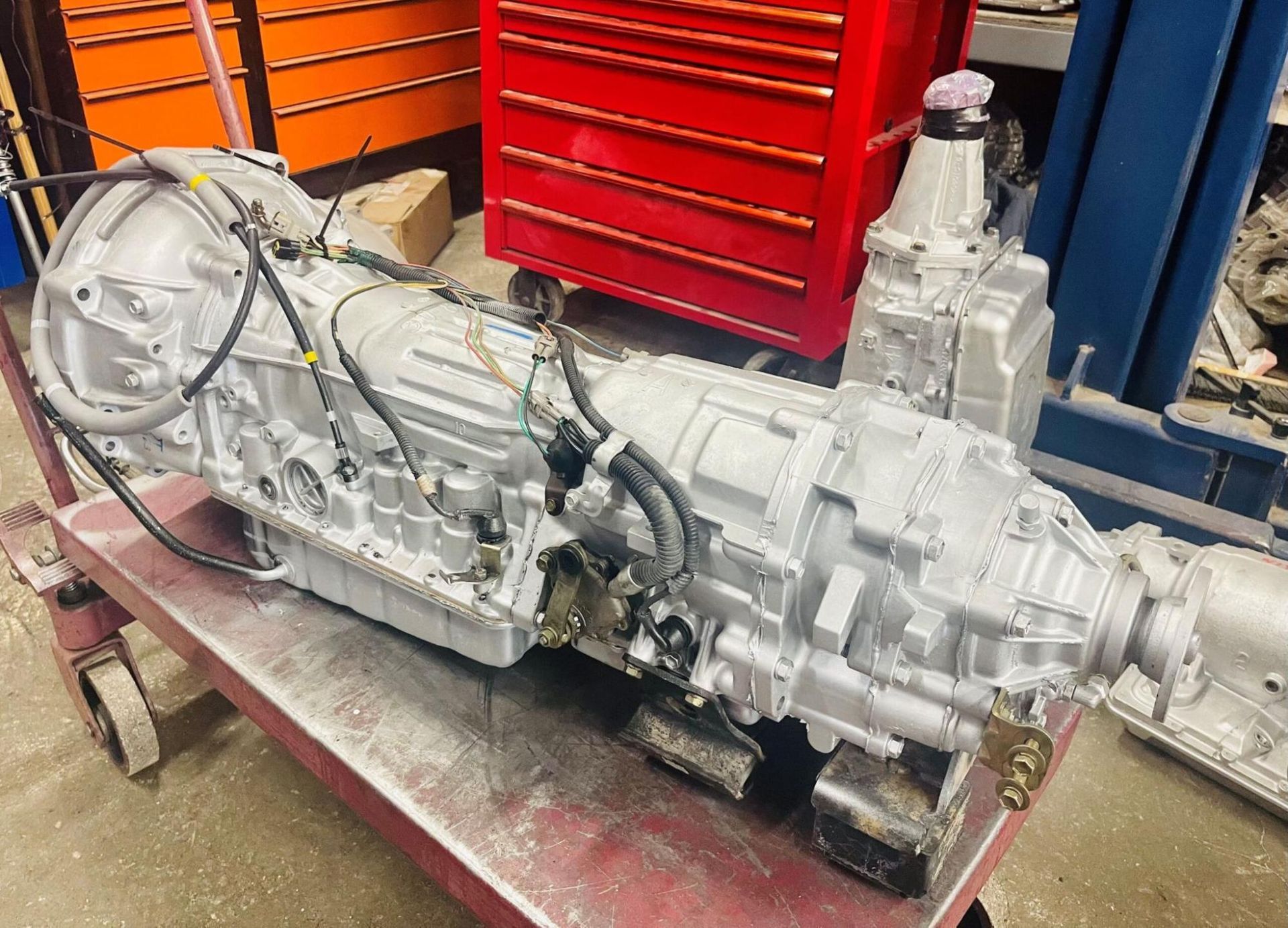A car engine is sitting on a cart in a garage.