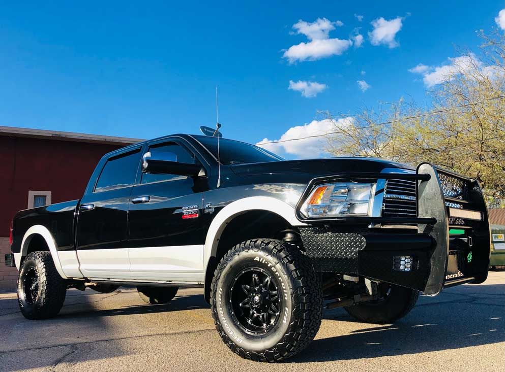 A black and white truck is parked on the side of the road.