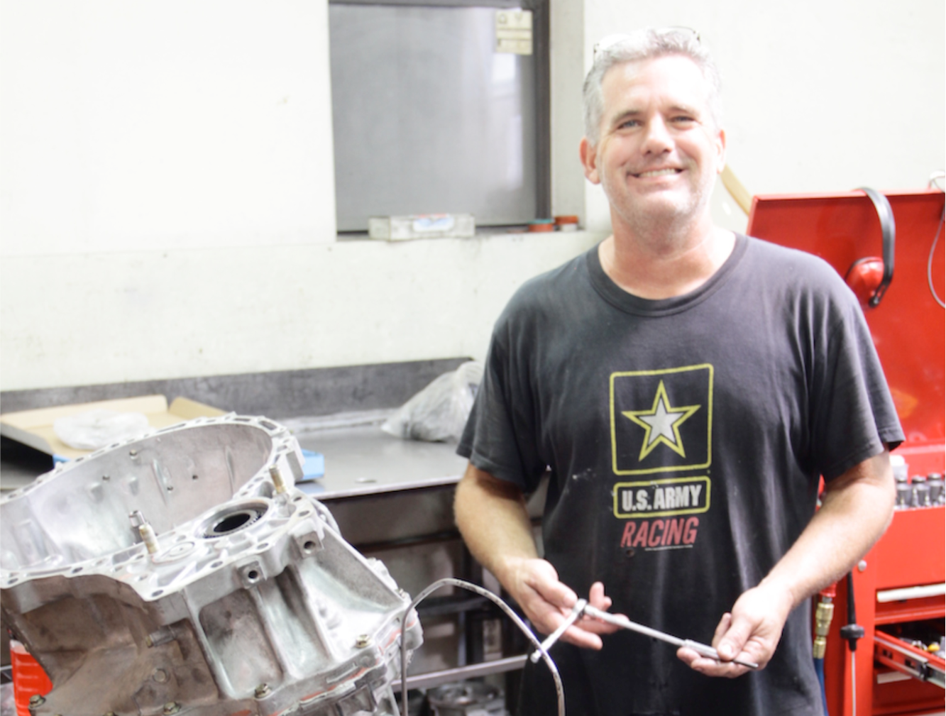 A man wearing a black u.s. army racing shirt