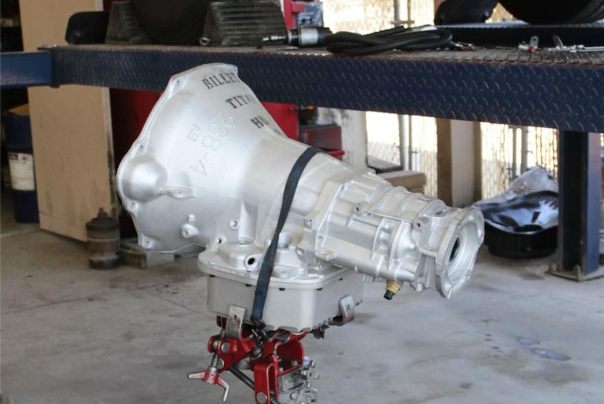 A gearbox is sitting on a lift in a garage
