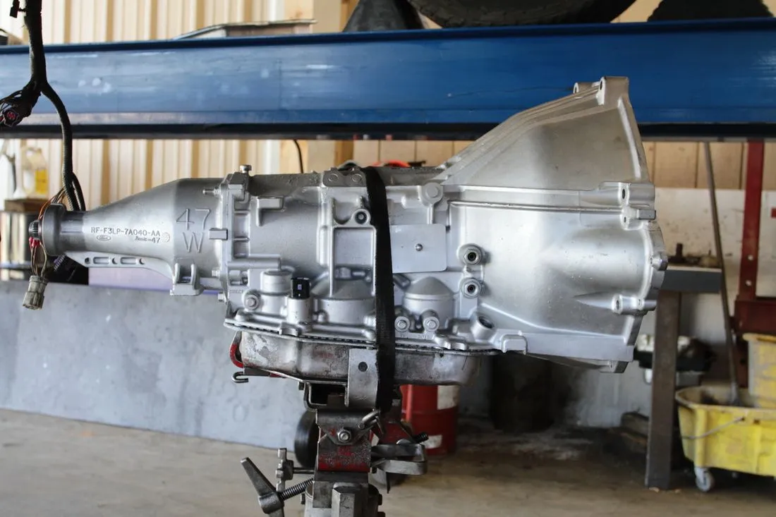 Large silver aircraft engine or turbine assembly in a workshop on a stand