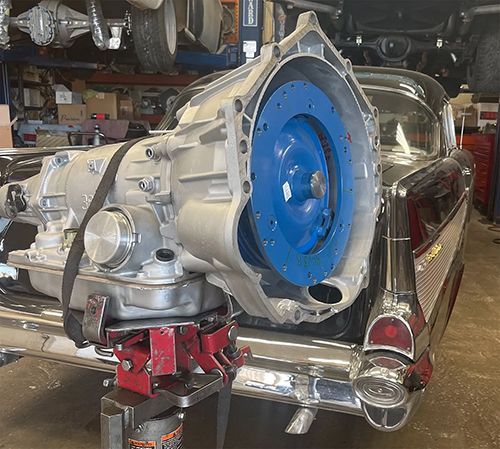 a car with a blue wheel is sitting on a jack in a garage .