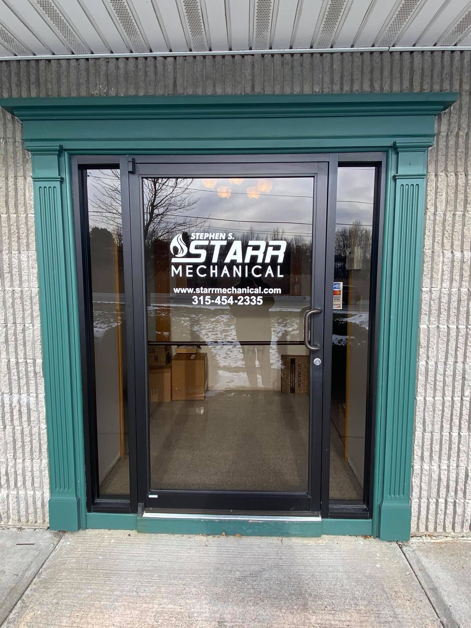 Front entrance of Starr Mechanical business with glass doors and black frame. Green trim.