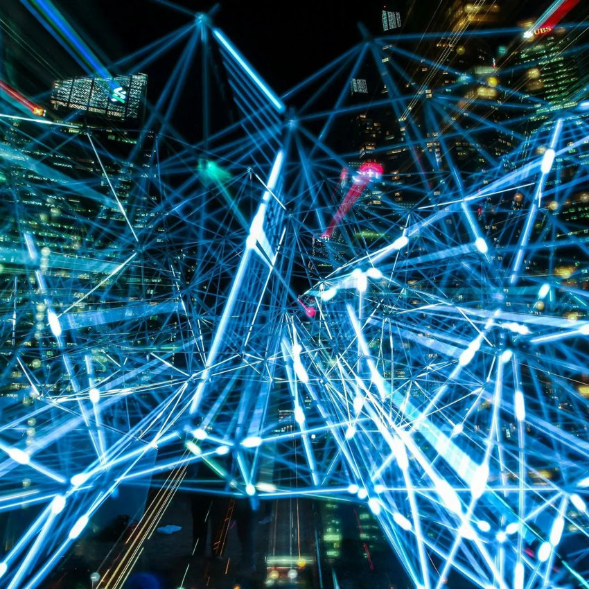Blue glowing network overlaying a city skyline at night.