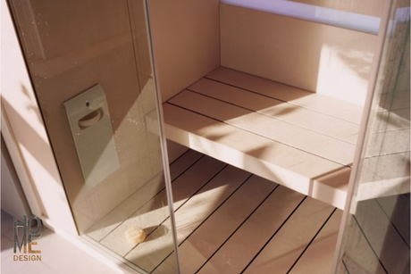 Sauna in vetro illuminata dal sole con panche in legno e pavimento piastrellato.