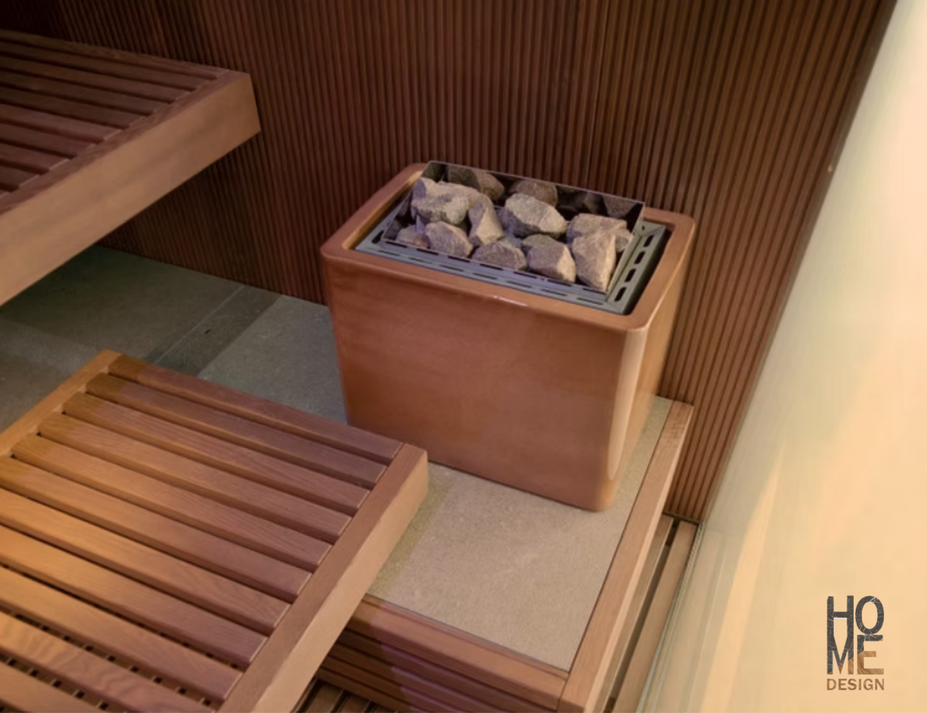 Sauna in legno con panche a doghe e stufa in pietra quadrata addossata a una calda parete in legno.