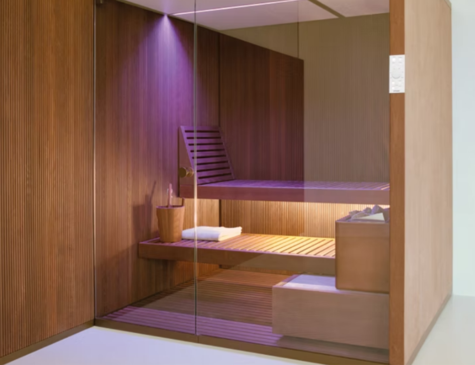 Moderna sala spa con pareti in legno, divisorio in vetro, illuminazione viola e lettino da massaggio.