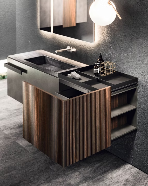 Mobile bagno moderno con dettagli in legno, lavabo integrato, specchio e applique rotonda in un elegante interno grigio.