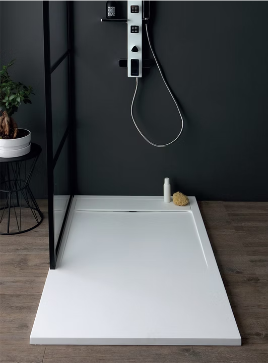 Bagno moderno con piatto doccia bianco a filo pavimento e rubinetteria a parete su una parete scura.