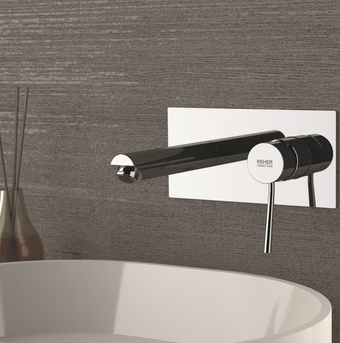 Rubinetto moderno cromato sopra un lavabo bianco, su una parete del bagno grigia e texturizzata.