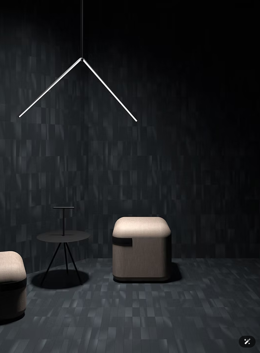 Stanza moderna e poco illuminata con due sgabelli, un tavolino e una lampada da parete geometrica bianca su uno sfondo scuro.
