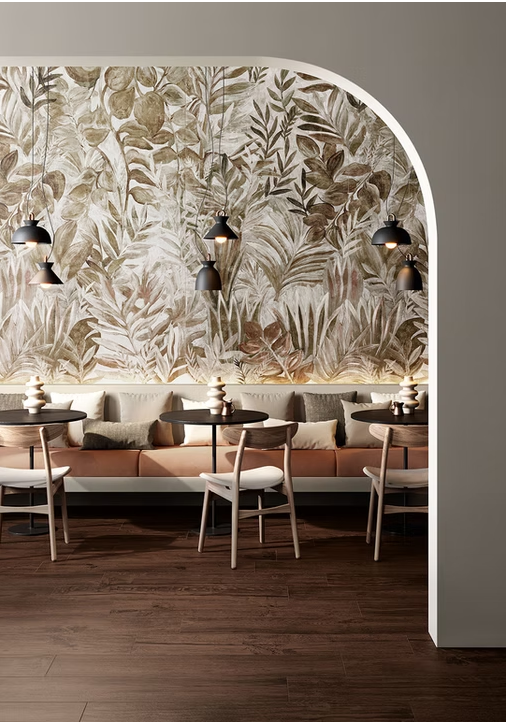 Interno moderno di un caffè con murale floreale ad arco, lampade a sospensione e tavoli in legno con sedie.