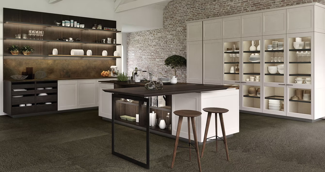 Showroom di cucine moderne con isola, sgabelli, mobili bianchi e mensole scure su pavimento in moquette.