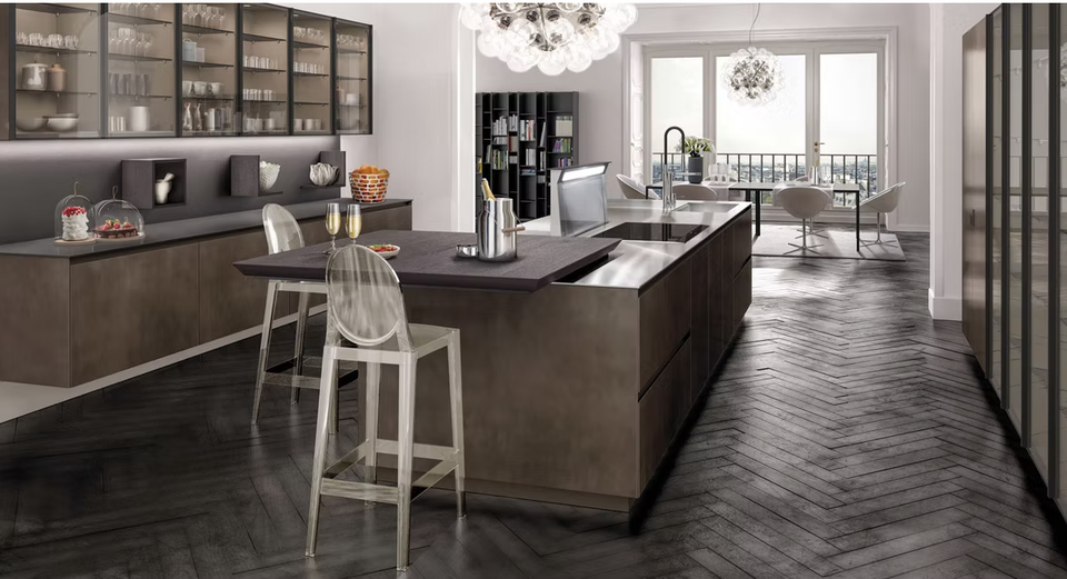 Cucina moderna con mobili in legno scuro, isola centrale e luminosa zona pranzo adiacente.