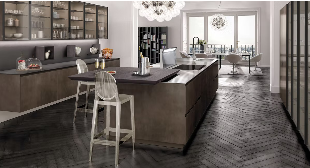 Cucina moderna con mobili in legno scuro, isola con posti a sedere e una luminosa zona pranzo adiacente.