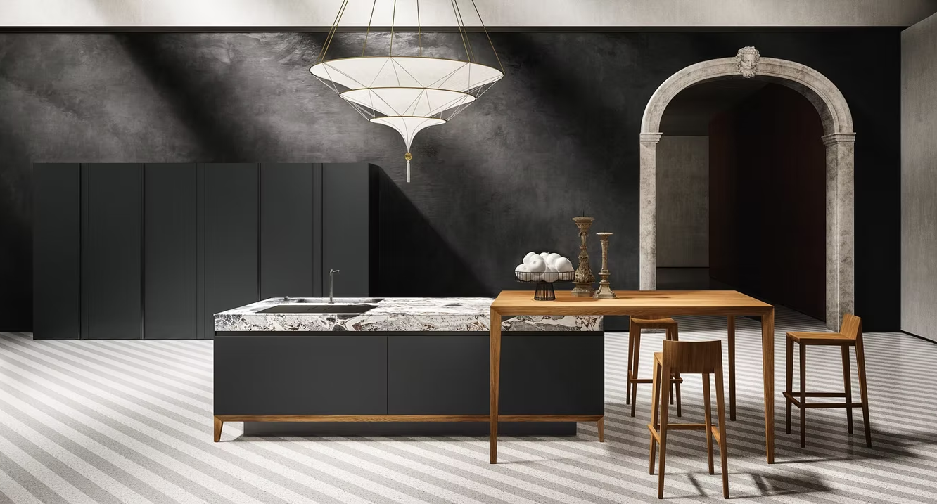 Cucina moderna con mobili neri, isola in marmo, tavolo da pranzo in legno e porta ad arco in un interno scuro.