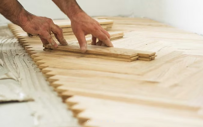 Mani che dispongono sottili listelli di legno su una superficie di lavoro chiara