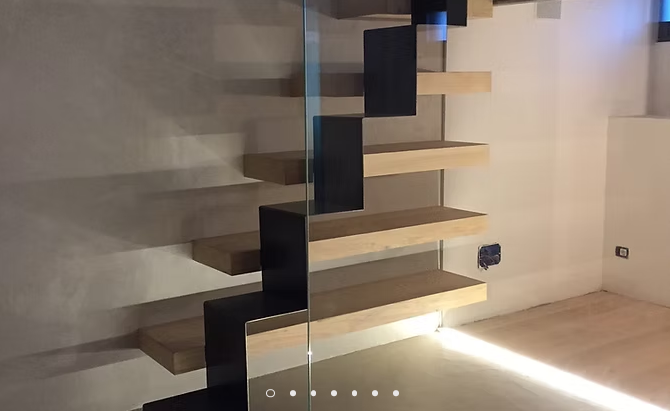 Scala moderna sospesa in legno con supporti scuri e illuminazione sotto i gradini in una stanza minimalista