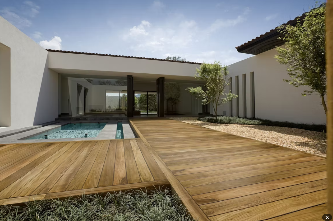 Cortile moderno con terrazza in legno, piccola piscina e patio con pareti in vetro esposto alla luce del sole.