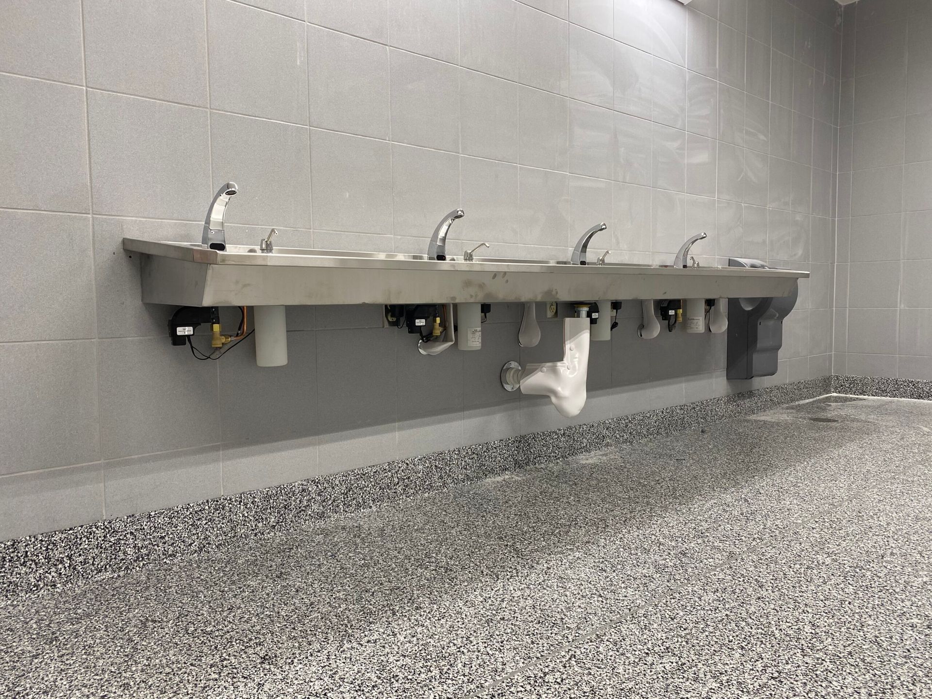 Stainless steel commercial kitchen with sinks, counters, and industrial cooking equipment