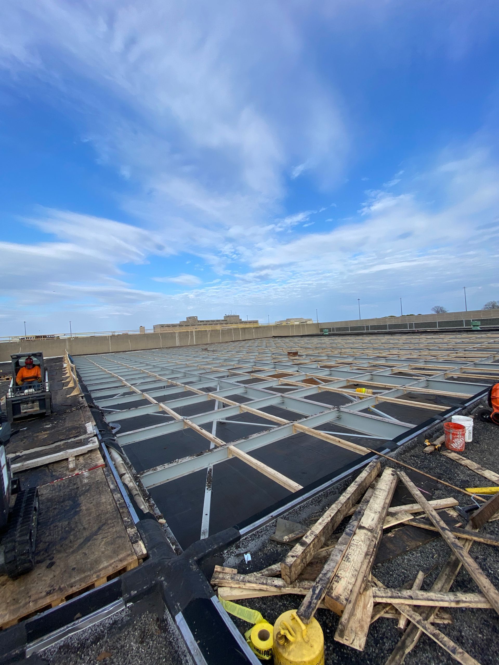 A construction site with a lot of wood and a blue sky in the background.