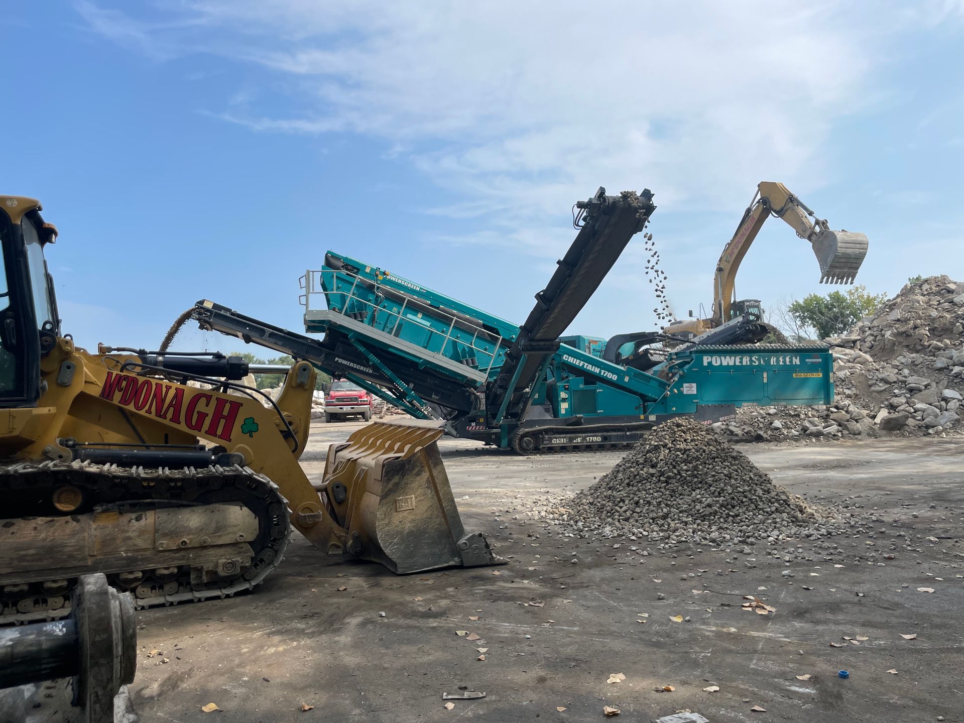 A bulldozer is loading a pile of rocks into a crusher.