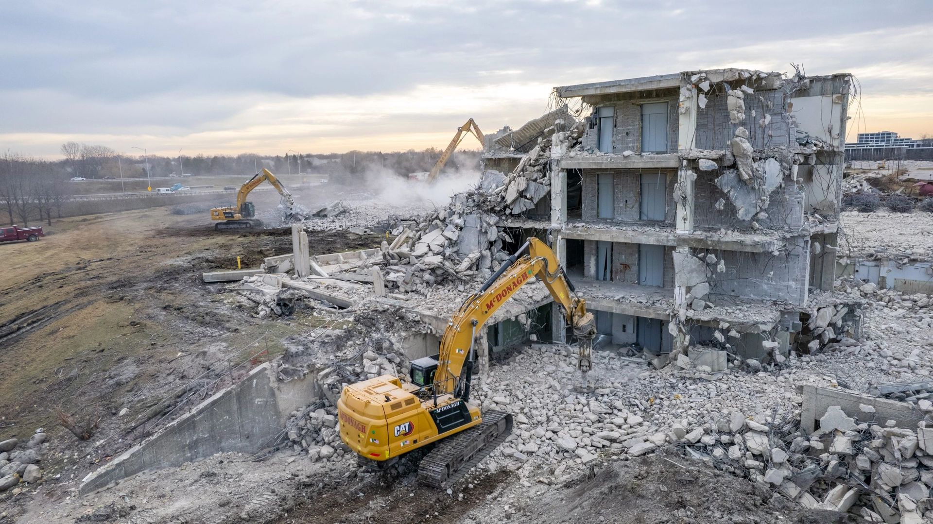An aerial view of a building being demolished by a bulldozer.