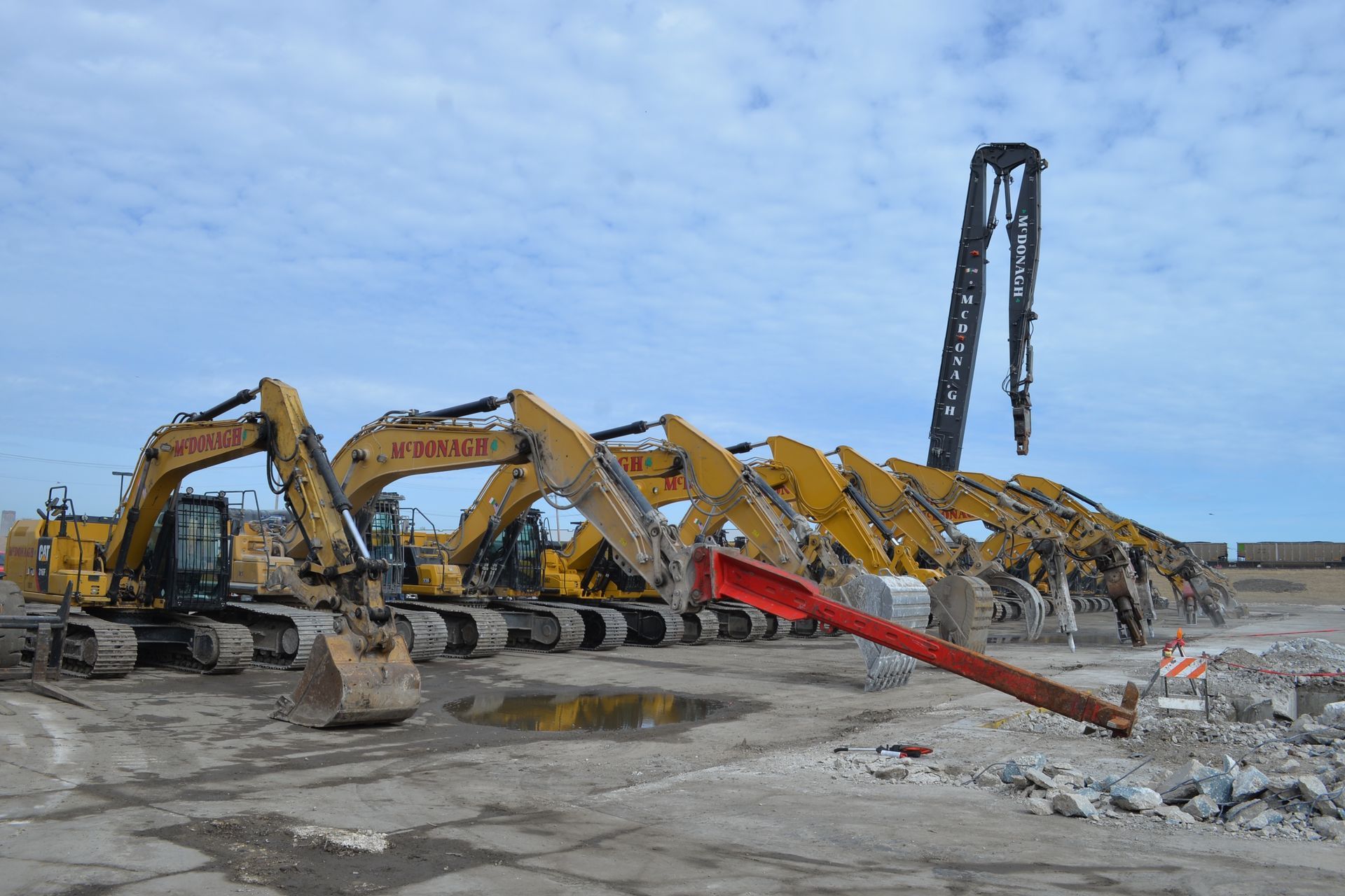 A large excavator is digging a hole in a grassy field.
