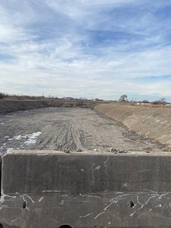 A large concrete block is sitting in the middle of a dirt field.