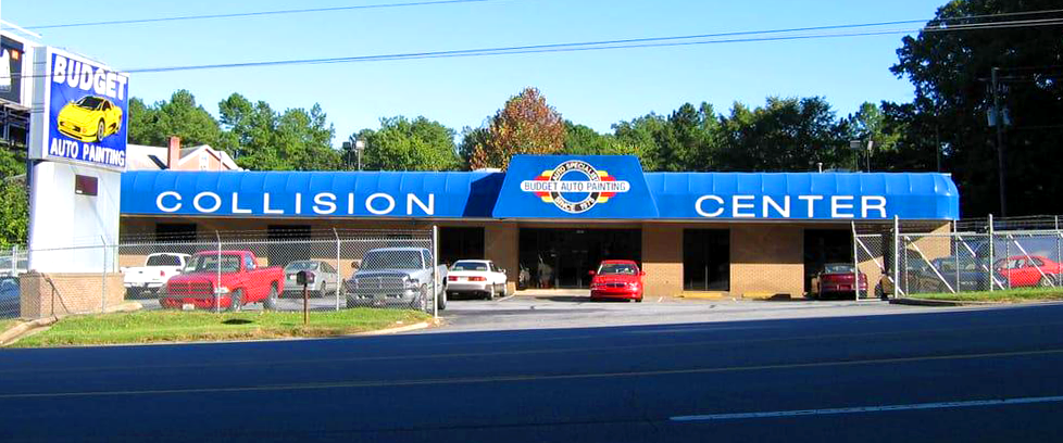 A collision center with cars parked in front of it