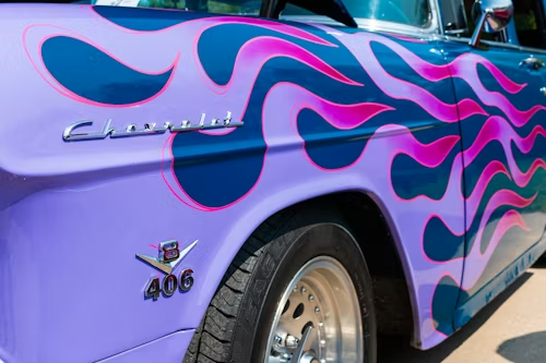 Purple classic Chevrolet car with flame paint design, 406 emblem.