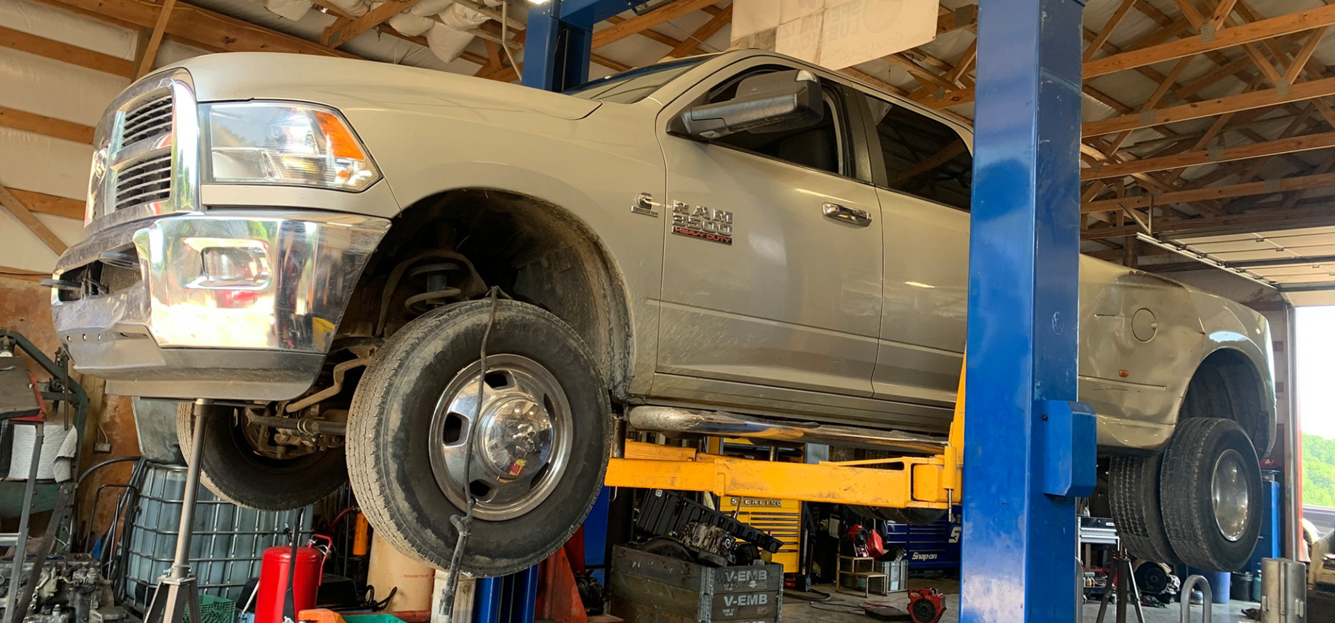 A truck is sitting on a lift in a garage.