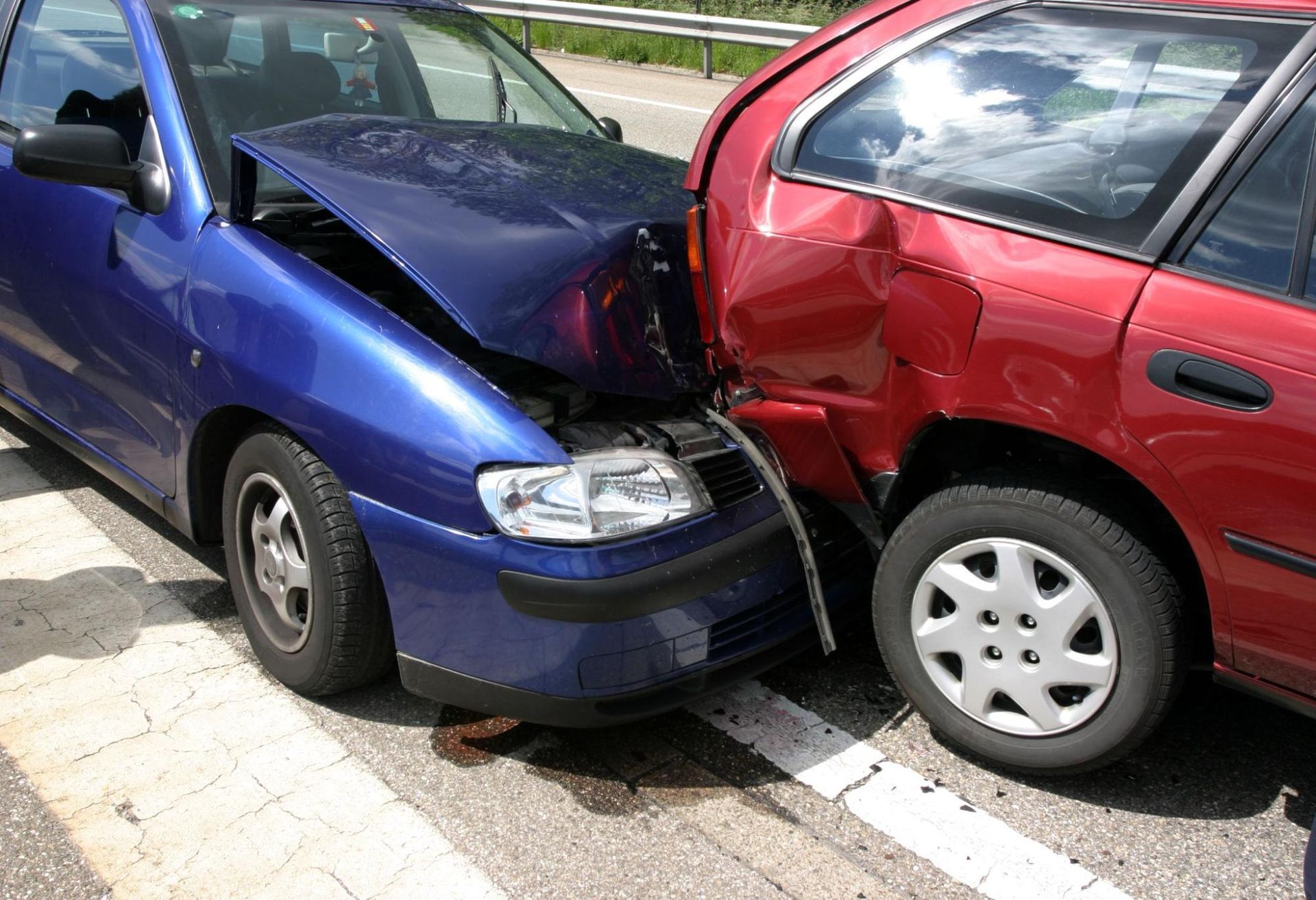 A blue car and a red car are involved in a car accident.